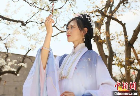 圖為蘭州青年身穿漢服在百年梨園賞景?！「哒?攝