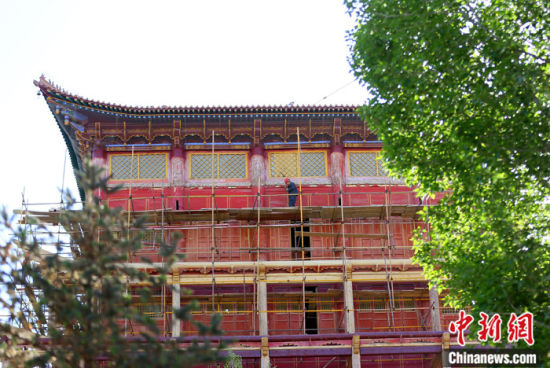 圖為5月上旬，甘肅山丹縣大佛寺內(nèi)，工作人員對(duì)古建筑大雄寶殿進(jìn)行修繕。 中新社記者 高展 攝