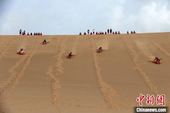 6月13日，敦煌鳴沙山月牙泉景區(qū)舉辦滑沙比賽。　張曉亮 攝