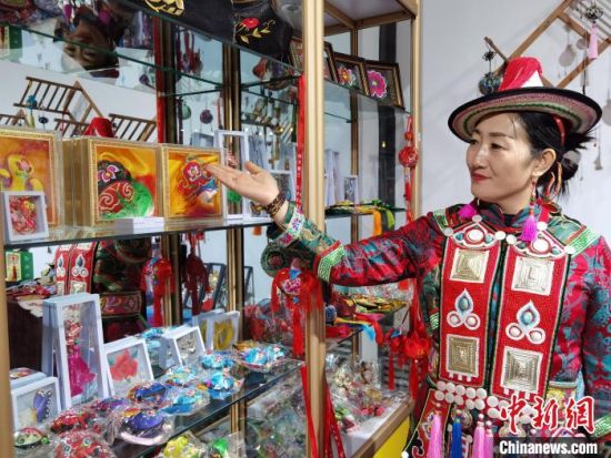 圖為身著民族服飾的隴原巧手展示手工藝品。(資料圖) 徐雪 攝