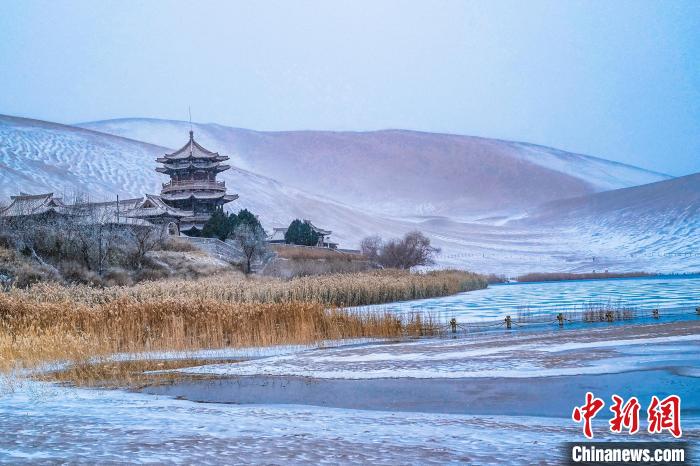 2021年11月28日，雪落鳴沙山月牙泉景區(qū)?！⊥醣筱y 攝