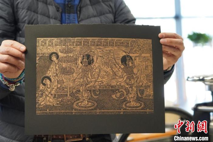 圖為手工書藝人展示敦煌雕版壁畫印刷品?！【琶赖┰?　攝