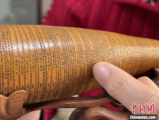 圖為長約二十公分的長條葫蘆雕刻佛教經(jīng)文作品?！堟?攝