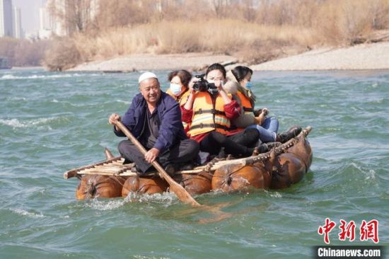 2月24日，年過(guò)七旬的蘭州羊皮筏子制作技藝第三代傳承人張德寶在黃河上劃著羊皮筏子。(資料圖) 九美旦增 攝