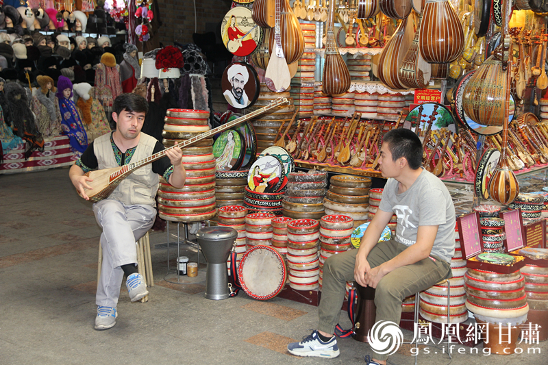 烏魯木齊二道橋巴扎內(nèi)，店主正在向客人展示樂器。楊文遠(yuǎn) 攝