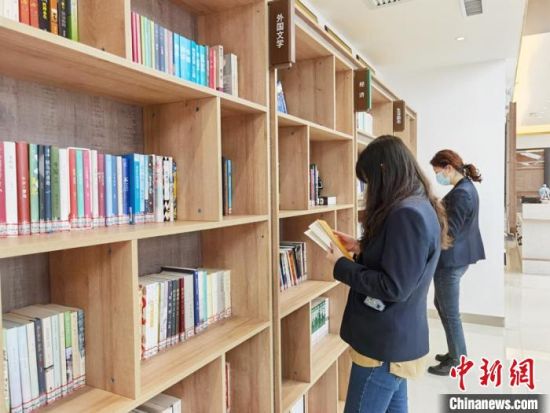 圖為在甘肅公航旅建設集團有限公司的職工書屋，職工挑選書籍?！⌒煅?攝