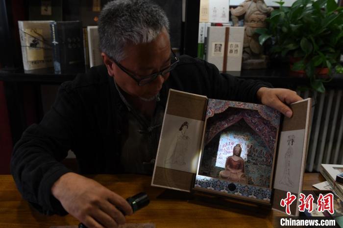 圖為讀者出版集團(tuán)讀者晉林工作室獨(dú)立出品人徐晉林，展示互動性強(qiáng)的敦煌題材手工書。(資料圖) 楊艷敏 攝