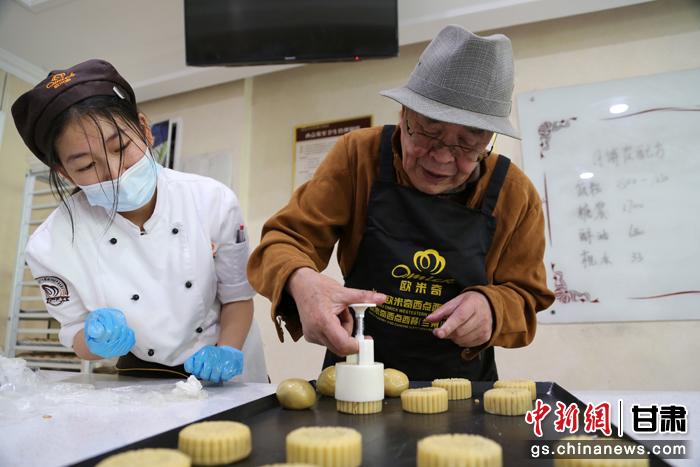 當(dāng)日，受邀參加活動的臺胞臺屬代表、兩岸婚姻及子女、在甘臺商代表等歡聚一堂。圖為77歲的在甘臺胞潘天鑒制作月餅。九美旦增 攝