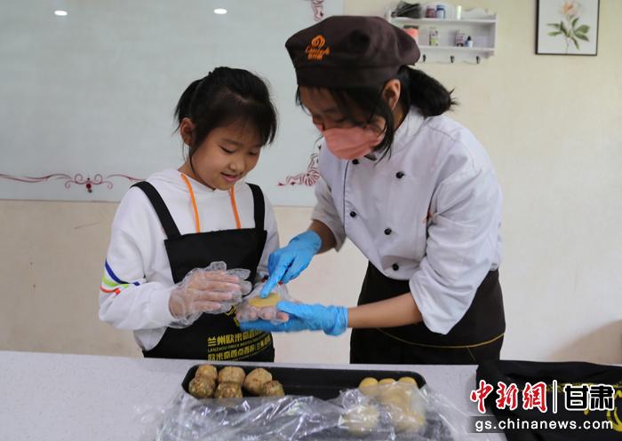 圖為在甘臺胞小朋友在工作人員指導(dǎo)下制作月餅。九美旦增 攝