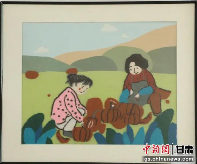 嘉峪關(guān)市新城鎮(zhèn)新城村農(nóng)業(yè)產(chǎn)業(yè)園區(qū)內(nèi)，母女兩人在摘南瓜。刺繡 馬艾米乃 繡稿 敬紅霞