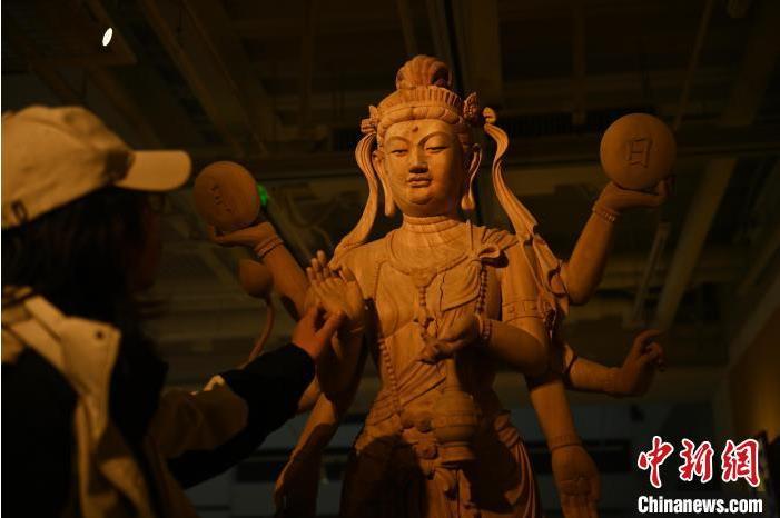 圖為季茂杰觀察自己創(chuàng)作的敦煌木雕。李亞龍 攝</p>
<p>