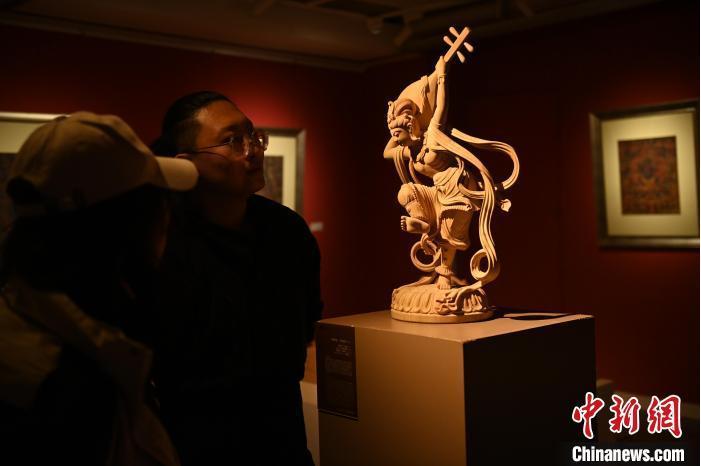圖為季茂杰向參觀者介紹自己創(chuàng)作敦煌木雕的過程。李亞龍 攝</p>
<p>