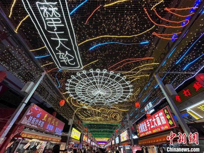 圖為明清街夜市燈光點(diǎn)亮具有武威文化元素的“摩天輪”彩燈?！〈魑牟?攝</p><p>