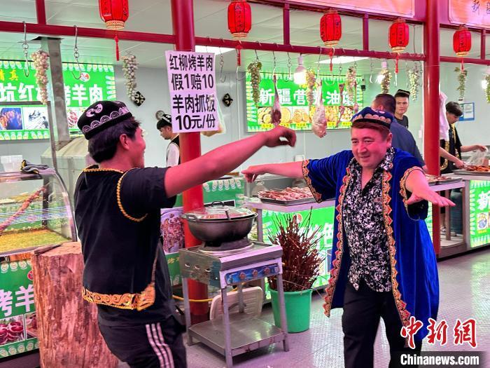 圖為餐飲經(jīng)營(yíng)者在“西涼不夜城”跳起舞蹈引客?！〈魑牟?攝</p><p>