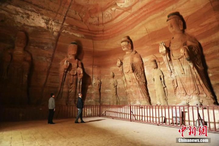 7月15日，游人參觀甘肅省平?jīng)鍪袥艽h百里石窟長廊中的南石窟寺1號(hào)窟。百里石窟長廊位于涇川縣境內(nèi)，由512個(gè)石窟、5眼窟中石井組成，現(xiàn)存王母宮石窟、鳳凰山石窟、南石窟寺、丈八寺石窟、羅漢洞石窟、太山寺石窟等規(guī)模較大的石窟群，還有數(shù)量眾多的小石窟群。南石窟寺開鑿于北魏永平三年，其中1號(hào)窟屬于大型七佛窟，七佛高達(dá)6米。中新社記者 李亞龍 攝